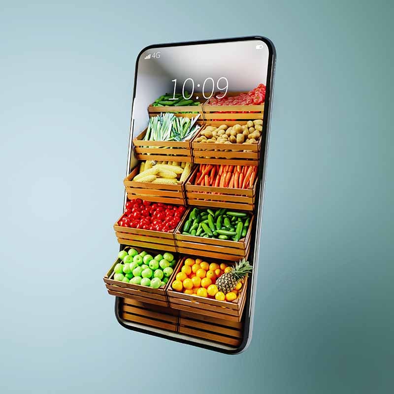 Smartphone toont houten kratten vol groenten en fruit, waaronder tomaten, paprika's, sla, mais en sinaasappels